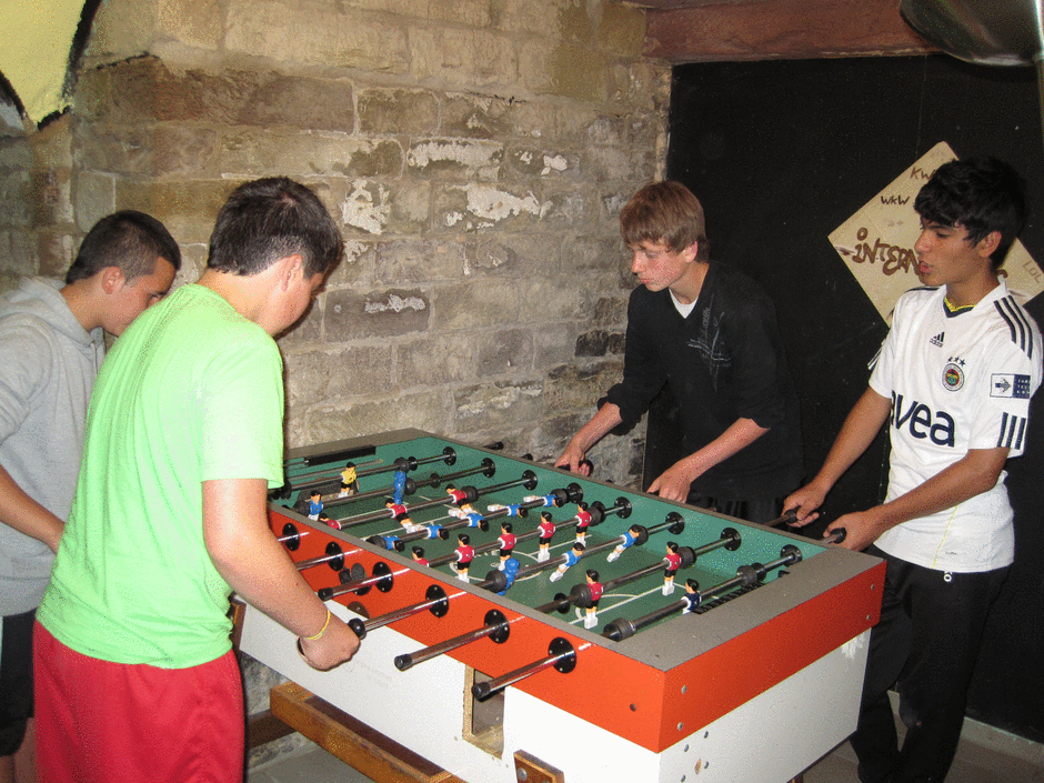 Jugendliche beim Tischkicker spielen